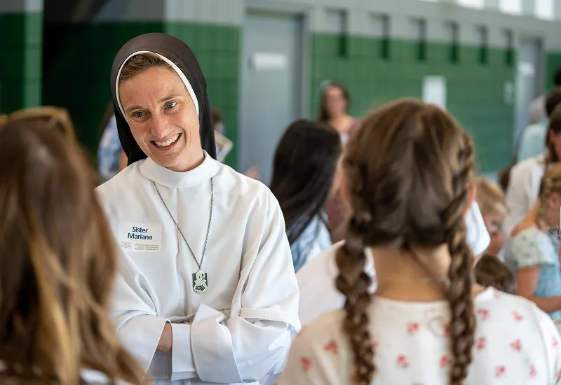 A religious sister smiles at two teenage girls, introducing them to the faith and virtue curriculum developed by the Dominican Sisters of Mary with Sister John Dominic.